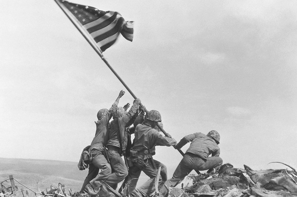 In this Feb. 23, 1945, photo, U.S. Marines of the 28th Regiment, 5th Division, raise an American flag atop Mount Suribachi, Iwo Jima, Japan. (AP Photo/Joe Rosenthal)