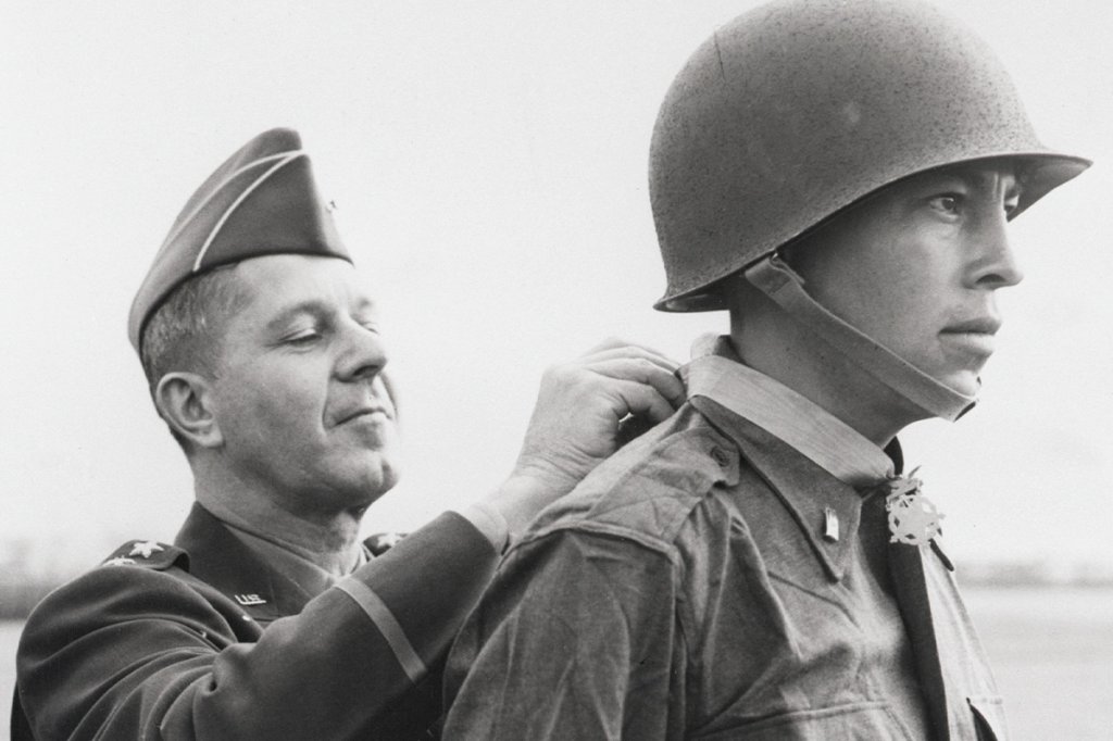 Original Caption) 4/23/1944-Italy: 2nd Lt. Ernest Childers, 26-year-old American Indian from Tulsa, OK, receives the Congressional Medal of Honor from Lt. Gen Jacob L. Devers (left), Deputy Supreme Commander of the US forces in the Mediterranian theater, in a ceremony at 5th Army headquarters. Lt. Childers received the honor because, working under heavy enemy fire, he wiped out 32 German machine gun nests near Oliveto, Italy, killing 5 Germans and capturing one. (Complete Caption in Envelope)