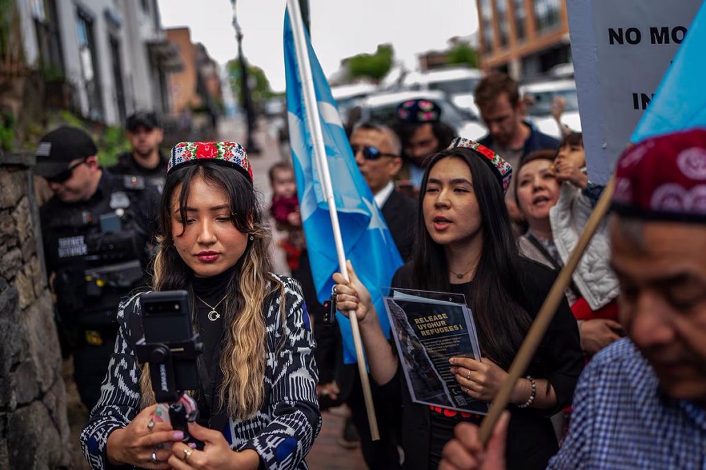 Shahrezad Ghayrat, a journalist with RFA's Uyghur language service, left, live-streams a Uyghur demonstration outside the Thai embassy in Washington, May 5, 2023. (Gemunu Amarasinghe/RFA)