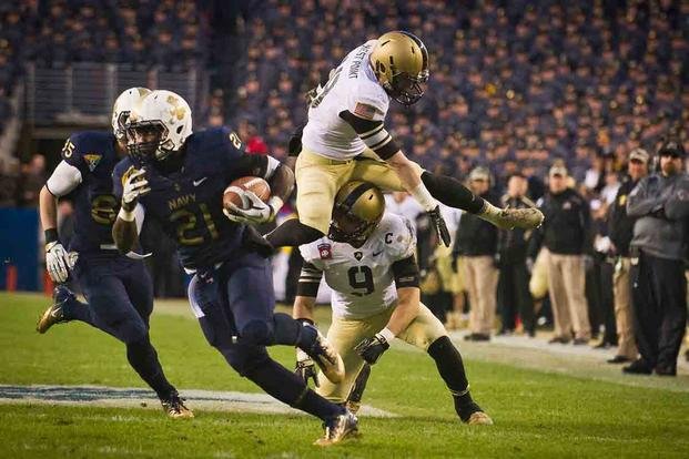 Navy running back Gee Gee Greene escapes 2 Army defenders during the 112th Army-Navy football game at FedEx Field in Landover, Maryland. (U.S. Navy/Mass Communication Specialist 2nd Class Kori Melvin) special uniforms