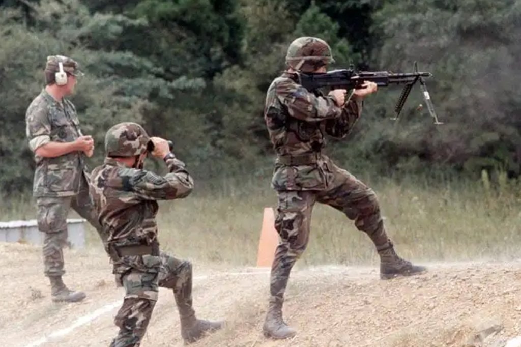 Sgt. Ronald Mann fires an M60 machine gun from the standing position during exercise Defender Challenge 1988. (U.S. Air Force/Staff Sgt. John K. McDowell)