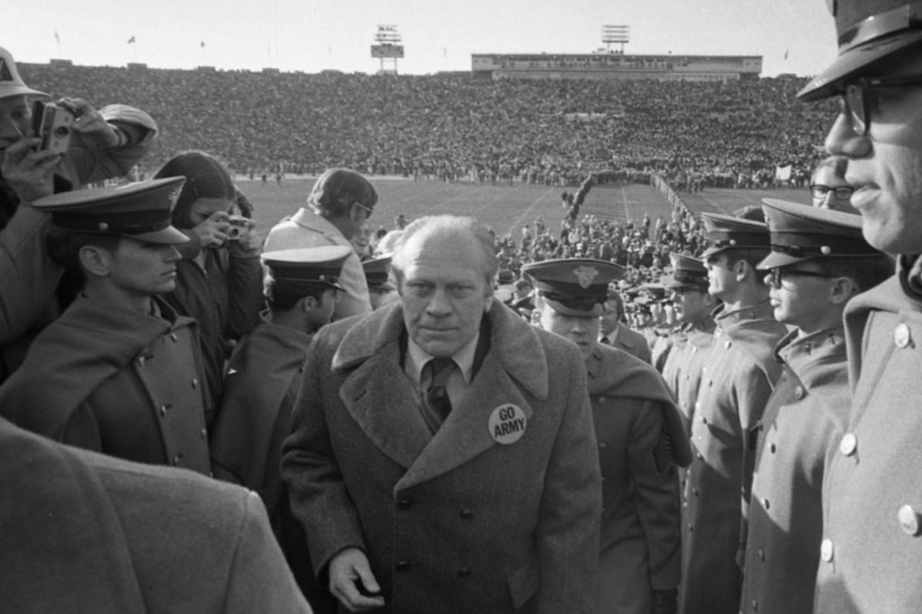 West Point Cadets watch President Gerald Ford go to his seat at halftime during the 1974 Army-Navy Game. That coat is a vibe. (National Archives)