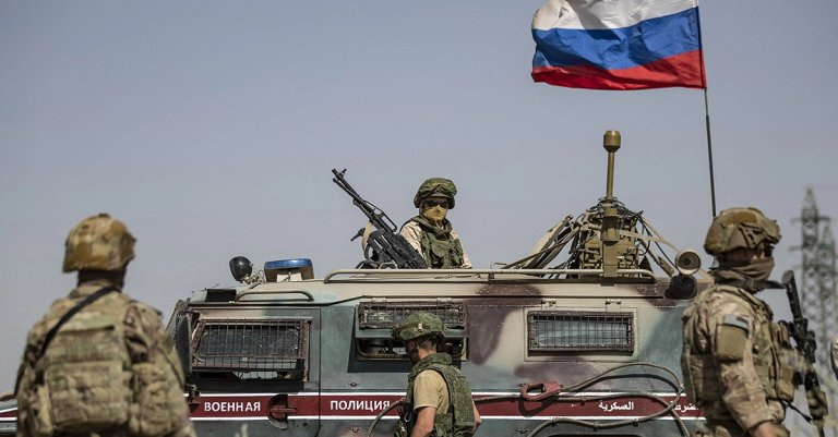 US soldiers stand near a Russian military vehicle in the northeastern Syrian town of al-Malikiyah (Derik) at the border with Turkey, on June 3, 2020. (Photo by DELIL SOULEIMAN / AFP) (Photo by DELIL SOULEIMAN/AFP via Getty Images)