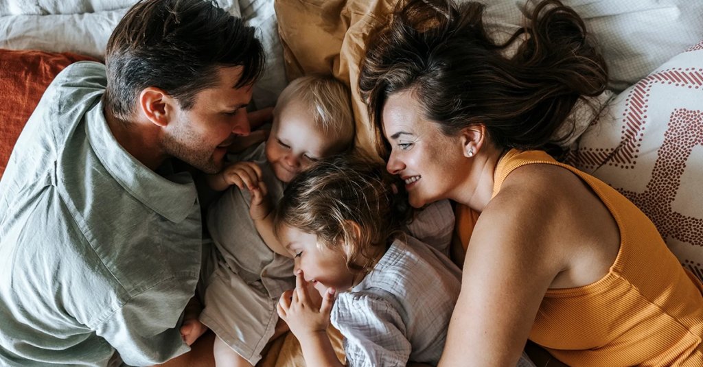 certificates military families Directly above shot of parents lying down on bed with son and daughter at home