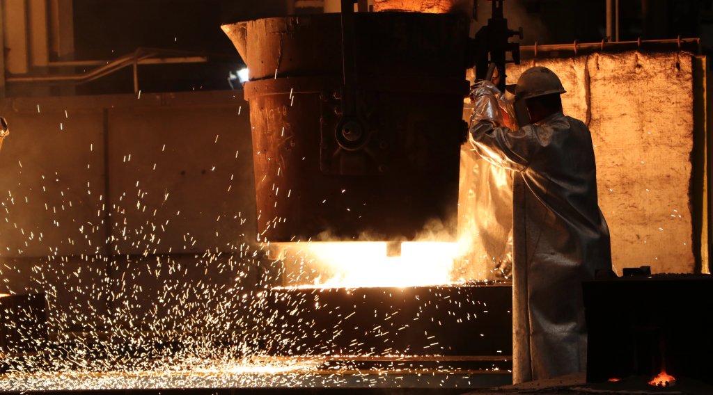 A Rock Island Arsenal-Joint Manufacturing and Technology Center artisan transports 3000-degree molten steel from the furnace to casting molds