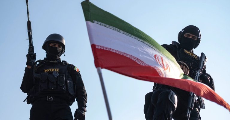 armed members of Iran's police special forces stand behind a country flag placed on an armored military vehicle during a pro-Government rally in downtown Tehran, Iran, on January 12, 2026. The rally takes place in Tehran against the recent anti-government unrest, opposition to the U.S. and Israel in Iran, and in support of Supreme Leader Ayatollah Ali Khamenei. no iran deal news getty