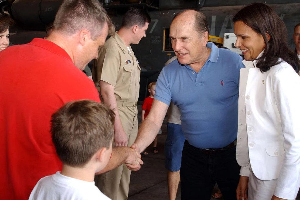 Actor Robert Duvall, wearing a blue shirt, and wife Luciana Pedraza shake hands with a member of the Navy's Helicopter Combat Support Squadron 4 at the Taormina Film Fest in Sicily, Italy, in 2005.