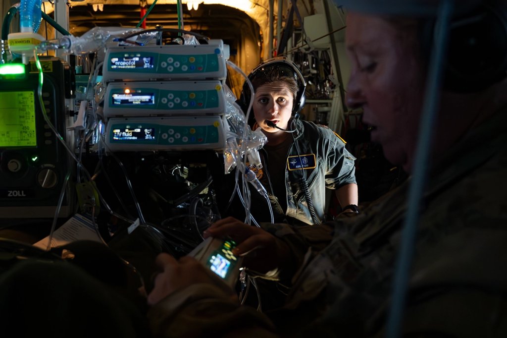 U.S. Air Force Maj. Ashley Sam, center, 375th Operations Medical Readiness Squadron (OMRS) critical care air transport team (CCATT) doctor, confers with Maj. Danielle Ogle, 375th OMRS CCATT registered nurse, on a C-130J Super Hercules military nurse