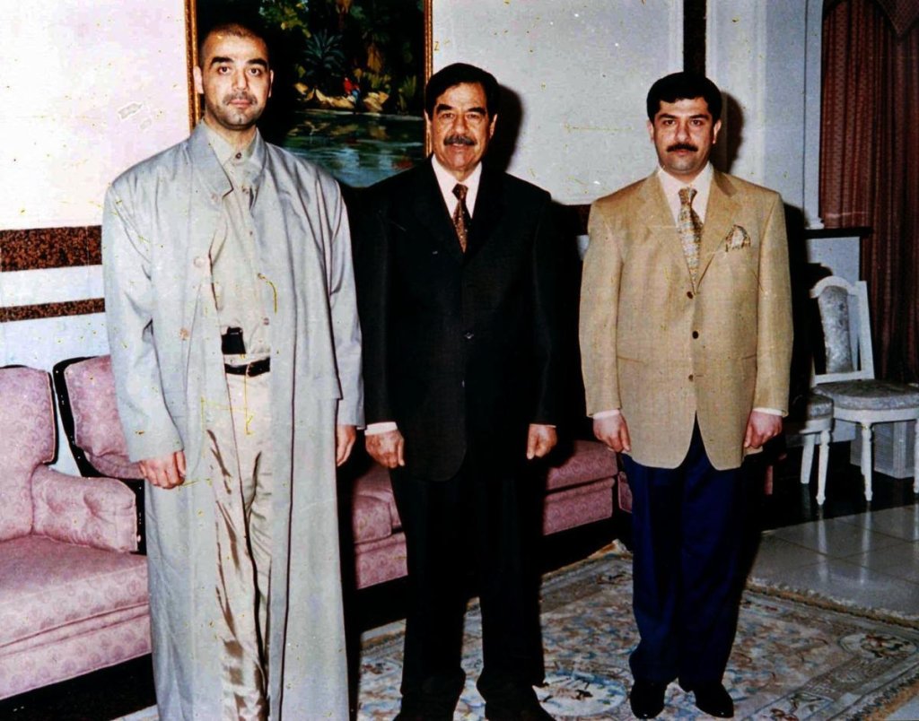 Iraqi ruler Saddam Hussein poses with his two sons Uday, left, and Qusay.
