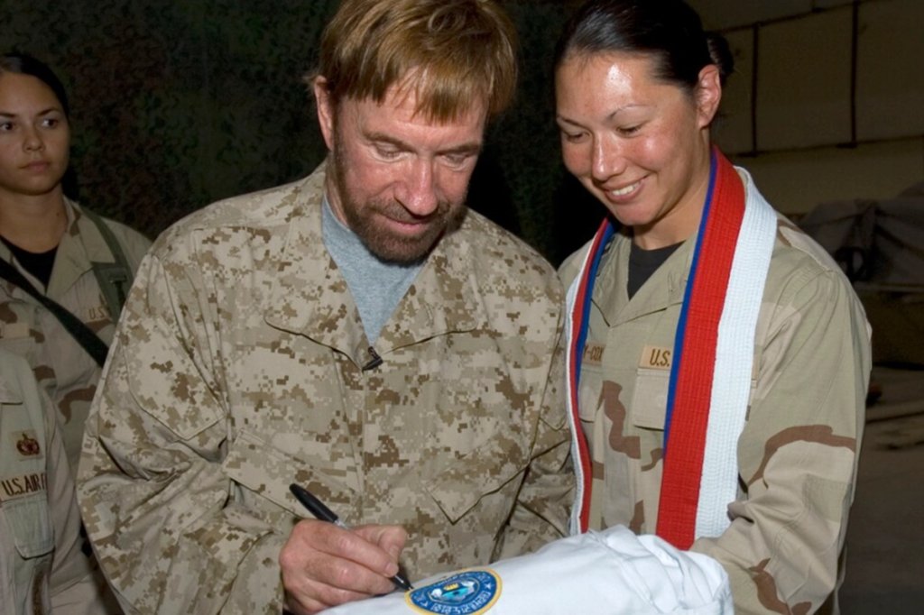  Capt Carla Stephany-Cox with the 386th Air Expeditionary Wing, gets an autograph signed by Walker, Texas Ranger star, Chuck Norris  dieswho is currently visiting troops in Southwest Asia. Capt. Stephany-Cox is deployed from Wright-Patterson AFB, OH. (U.S. Air Force Photo by Staff Sgt. Tia Schroeder)