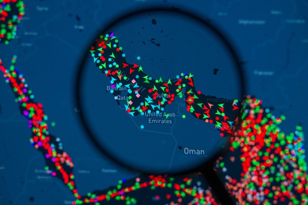 A MarineTraffic map showing ship movements in the Strait of Hormuz is pictured through a magnifying glass in this photo illustration, as commercial vessel traffic through the key oil shipping lane drops sharply amid the escalating conflict involving Iran. Taken in Brussels, Belgium, on March 15, 2026. (Photo by Jonathan Raa/NurPhoto via Getty Images)