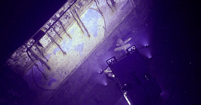 Remotely operated vehicle Deep Discoverer descends into the midships elevator shaft of USS Yorktown (CV-5) during the Beyond the Blue: Papahānaumokuākea ROV and Mapping expedition to image the mural “A Chart of the Cruises of USS Yorktown.” Image courtesy of NOAA