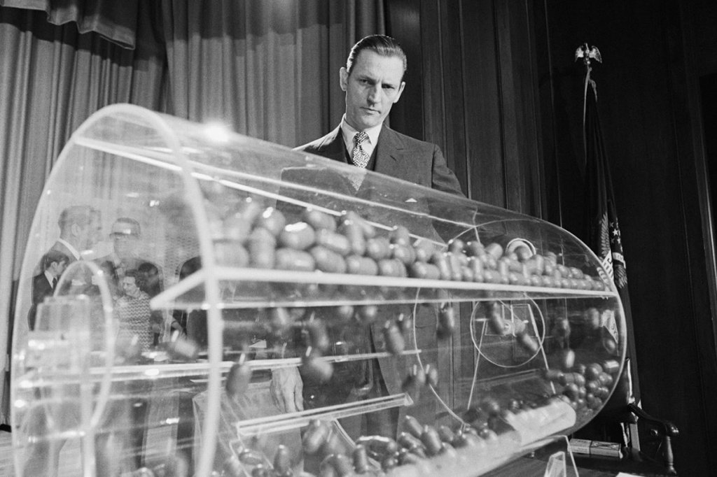what happens in a draft Selective Service Director Curtis Tarr spins the drum containing the sequence capsules, as the draft lottery got underway in the Commerce Department auditorium. The lottery was to determine the callup order of nearly 2 million young men turning 19 this year on the basis of pairing of 365 capsules containing the days of the year and an equal number of blue capsules containing draft sequence numbers 1 through 365.
