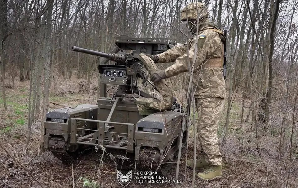 a soldier from the 46th Separate Air Assault Brigade loading the ammunition into the weapon system for a ground robot.