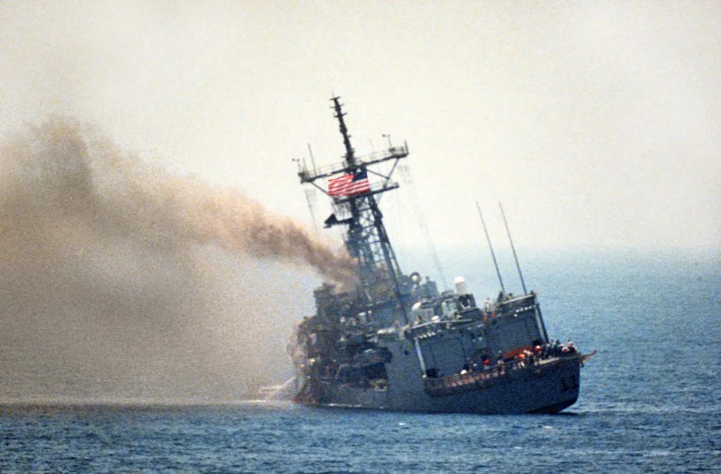 A port quarter view of the guided missile frigate USS Stark listing to port after being hit by two Iraqi Exocet missiles within 30 seconds. 37 sailors were killed.