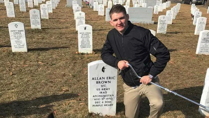 Army Spc. Winston Hencely poses for a photo with his service dog at Arlington National Cemetery in Arlington, Va. Hencely, a U.S. soldier grievously wounded in a suicide bombing two years ago in Afghanistan, filed suit Wednesday, Feb. 20, 2019, against an American defense contractor that employed the bomber, saying it failed to supervise the man as he built an explosive vest on the job using the company's tools and parts. (Vicki Hencely)