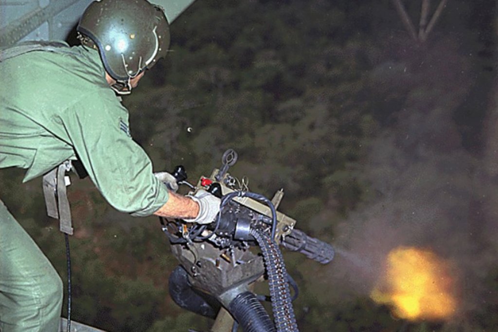 A U.S. Air Force Sikorsky HH-53E helicopter crewman fires a M134 mini-gun during rescue patrol over South Vietnam.