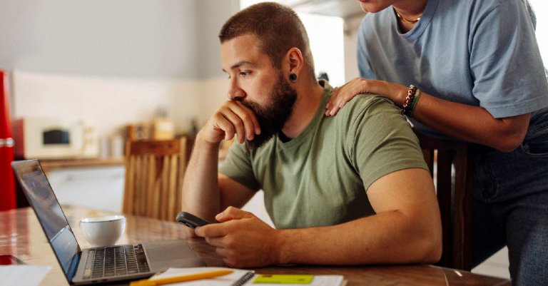 Focused Man Managing Finances on Laptop at Home