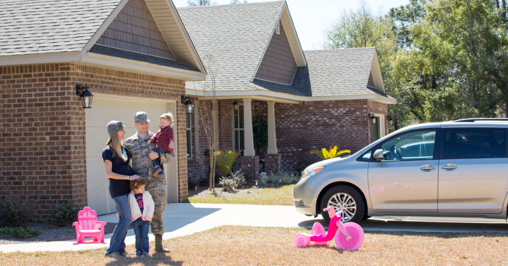 Portrait of male soldier, pregnant wife and daughters in garden at air force military base
