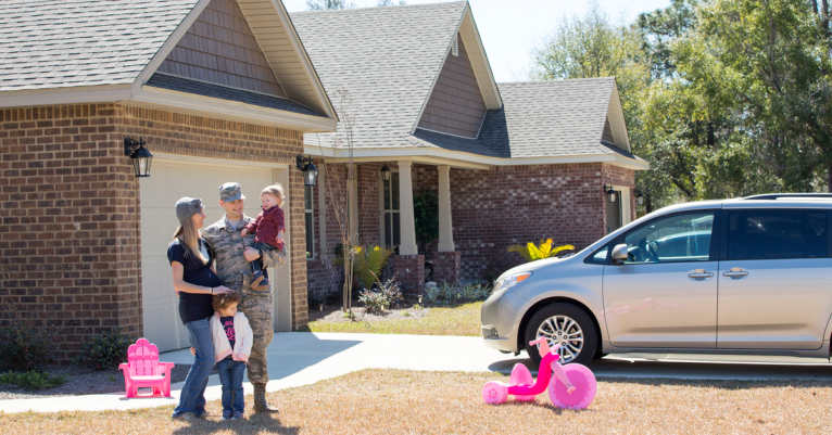 Portrait of male soldier, pregnant wife and daughters in garden at air force military base
