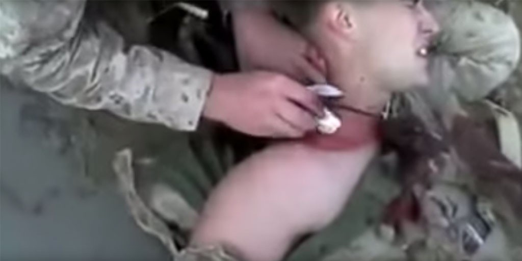 This Marine walks off the battlefield after being shot in the neck